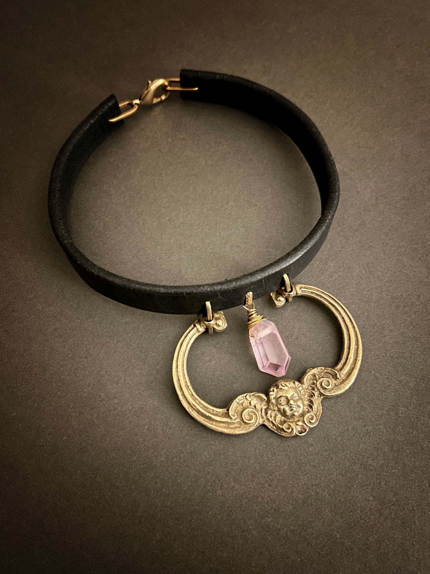 Black tack leather choker with antique cherub hardware and faceted kunzite